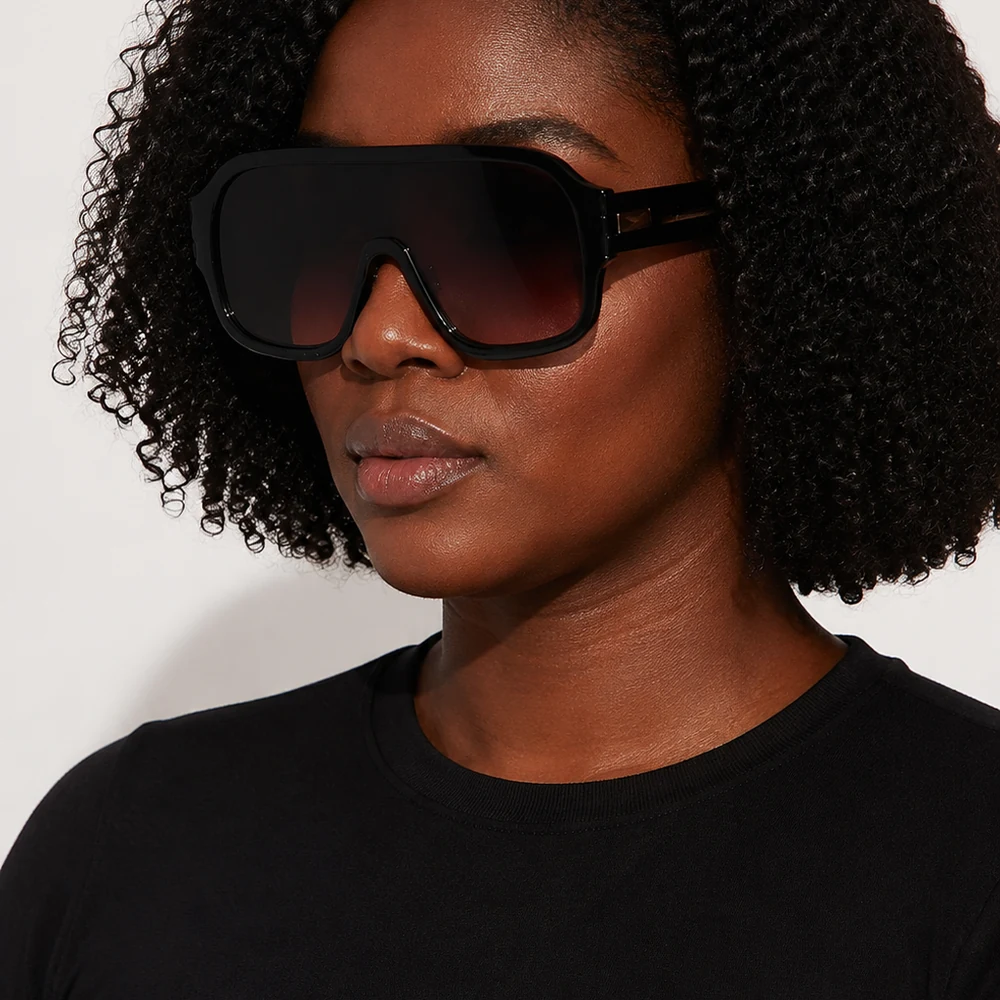 mammoth-rider-black-oversized-shield-sunglasses-worn-01 Black oversized shield sunglasses with purple gradient lenses worn on a model