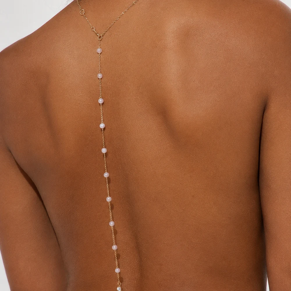 power-to-her-gold-rhinestone-body-chain-back-view-01 Gold-tone rhinestone body chain with a center back drop worn with an open-back black outfit